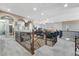 A spacious loft area with carpeted floors, detailed iron railings, and arched entryways at 7778 Villa Montara St, Las Vegas, NV 89123