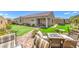 Inviting backyard showcasing a manicured lawn, comfortable seating, and a cozy outdoor fire pit at 8269 Skye Peak St, Las Vegas, NV 89166