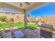 Inviting outdoor space with a covered patio, BBQ, lush lawn, and desert landscaping at 8269 Skye Peak St, Las Vegas, NV 89166