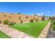 Manicured backyard featuring a putting green, desert landscaping, and a storage shed at 8269 Skye Peak St, Las Vegas, NV 89166