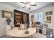 Home office with custom built-in bookcase, decorative accents, a ceiling fan, and natural light from the window at 8269 Skye Peak St, Las Vegas, NV 89166