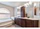 A luxurious bathroom featuring a soaking tub, dual sinks, and custom cabinets at 8275 Old Creek Ranch St, Las Vegas, NV 89139