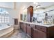 Spacious bathroom with dark wood cabinets, double sinks, and a separate tub at 8275 Old Creek Ranch St, Las Vegas, NV 89139