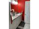 Bathroom with a red wall, granite countertop, dual sinks, and stylish fixtures at 8516 Millsboro Dr, Las Vegas, NV 89134