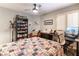 This cozy bedroom features a ceiling fan, a bookcase and a beautiful quilt-covered bed at 8516 Millsboro Dr, Las Vegas, NV 89134