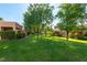 Well-maintained front lawn with lush greenery and mature trees shading charming single-story homes at 8516 Millsboro Dr, Las Vegas, NV 89134