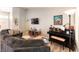 Cozy living room with sectional couch, modern decor, and a piano for entertaining at 8516 Millsboro Dr, Las Vegas, NV 89134
