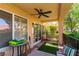 Inviting covered patio with ceiling fan, seating and view of well-manicured yard at 8516 Millsboro Dr, Las Vegas, NV 89134