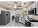 Bright kitchen with stainless steel appliances, white cabinets, modern flooring, and an adjacent laundry room at 8629 Prairie Hill Dr, Las Vegas, NV 89134