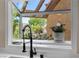Bright kitchen window offering a view of the lush, landscaped backyard at 8629 Prairie Hill Dr, Las Vegas, NV 89134