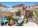 Relaxing outdoor area with a stone fire pit, comfortable seating, shade umbrella and vibrant plants for serene living at 8629 Prairie Hill Dr, Las Vegas, NV 89134