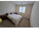 Cozy bedroom with neutral carpet, minimalist decor, and natural light from the window at 8665 Jerlyn St, Las Vegas, NV 89113