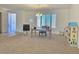Bright room featuring carpet, a ceiling fan, a work station, and ample natural light from large windows at 8665 Jerlyn St, Las Vegas, NV 89113