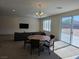 Spacious open-concept living area features a dining table and sliding glass doors to the backyard at 8665 Jerlyn St, Las Vegas, NV 89113