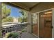 A balcony with views of trees and the property, with a glimpse of the interior through the sliding door at 9050 W Warm Springs Rd # 2051, Las Vegas, NV 89148
