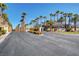 Paved road leading into community is lined with palm trees and green foliage at 9050 W Warm Springs Rd # 2051, Las Vegas, NV 89148