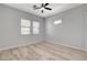 Bright bedroom featuring neutral walls, wood-look floors, ceiling fan, and two windows at 924 Allister Fields Ln, Las Vegas, NV 89138