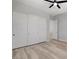 Bedroom featuring sliding door closet, light wood-look floors, and white walls at 924 Allister Fields Ln, Las Vegas, NV 89138