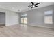 Bright, open living room with hardwood floors, a ceiling fan, and a sliding glass door to the backyard at 924 Allister Fields Ln, Las Vegas, NV 89138