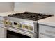 Close-up view of a gas range with stylish gold knobs and light countertops at 924 Allister Fields Ln, Las Vegas, NV 89138