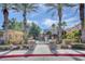 Community pool area with mature palm trees, green landscaping and secure fencing at 9303 Gilcrease Ave # 2198, Las Vegas, NV 89149
