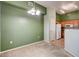 A dining room with green accent wall, carpet, and modern chandelier at 9303 Gilcrease Ave # 2198, Las Vegas, NV 89149