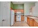 Kitchen featuring wood cabinets, white appliances, and tile flooring at 9303 Gilcrease Ave # 2198, Las Vegas, NV 89149