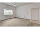 A well lit and open living room featuring carpet, a window, and a white front door at 9303 Gilcrease Ave # 2198, Las Vegas, NV 89149