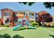 Community playground with colorful slides and lush landscaping, set against townhome buildings at 9303 Gilcrease Ave # 2198, Las Vegas, NV 89149