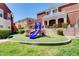 Community playground with colorful equipment and artificial turf, surrounded by well-maintained landscaping at 9303 Gilcrease Ave # 2198, Las Vegas, NV 89149