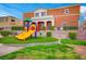 Community playground with colorful slides and artificial turf, next to modern townhomes at 9303 Gilcrease Ave # 2198, Las Vegas, NV 89149