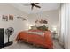 Cozy bedroom with an orange comforter, ceiling fan, and warm lighting at 9710 Hiking Ave, Las Vegas, NV 89166