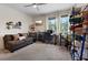Bright bedroom with large windows, a comfortable sofa, and a ceiling fan at 9710 Hiking Ave, Las Vegas, NV 89166