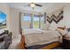 Cozy bedroom with a comfortable bed, large windows offering natural light, and stylish wall decor at 9710 Hiking Ave, Las Vegas, NV 89166