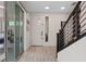 Bright foyer with wood-look tile flooring and modern staircase design at 9710 Hiking Ave, Las Vegas, NV 89166