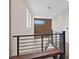 Modern hallway with a dark wood feature wall, contemporary railing, and ample natural light at 9710 Hiking Ave, Las Vegas, NV 89166