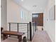 Bright hallway with a wood accent wall and a modern metal railing, leading to the upper floor at 9710 Hiking Ave, Las Vegas, NV 89166
