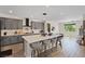 Contemporary kitchen with gray cabinets, a large white island, and barstool seating, ideal for entertaining at 9710 Hiking Ave, Las Vegas, NV 89166