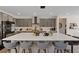 A gourmet kitchen featuring gray cabinets, a large white island, sleek appliances, and modern barstool seating at 9710 Hiking Ave, Las Vegas, NV 89166
