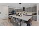 An expansive kitchen with modern gray cabinets, a large white countertop island, and sleek barstool seating at 9710 Hiking Ave, Las Vegas, NV 89166
