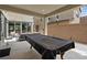 Rear patio features outdoor seating, lighting, and glass sliding doors into the home at 9710 Hiking Ave, Las Vegas, NV 89166