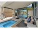 Relaxing covered patio area with hot tub and views of the backyard pool and TV at 9710 Hiking Ave, Las Vegas, NV 89166
