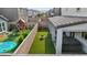 Aerial view of a backyard with artificial grass, covered patio, hot tub, playground, and well-maintained landscaping at 10057 Matter Overlook Dr, Las Vegas, NV 89178