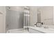 Cozy bathroom features a shower with a bathtub, modern faucet, and gray-striped shower curtain at 10057 Matter Overlook Dr, Las Vegas, NV 89178