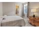 Simple bedroom showcasing a bright interior, adjacent bathroom, and wooden dresser at 10057 Matter Overlook Dr, Las Vegas, NV 89178