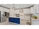Modern kitchen with white cabinets, stainless steel appliances, and a blue accent island at 10057 Matter Overlook Dr, Las Vegas, NV 89178