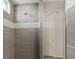 Modern shower with gray tile, dual shower heads, and a bench at 10057 Matter Overlook Dr, Las Vegas, NV 89178