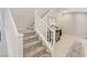 Carpeted staircase with white railings, and a decorative mirror, enhancing the home's modern, inviting ambiance at 10057 Matter Overlook Dr, Las Vegas, NV 89178