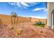 Desert landscaped backyard featuring a rock groundcover, privacy walls and small table and chairs at 1013 Gentle Swan St # 696, Henderson, NV 89011