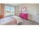 Bedroom with pink accents, a white bed, pink dresser, and mountain views through a large window at 1013 Gentle Swan St # 696, Henderson, NV 89011